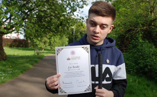 Lee Roake holding his Coronation Champions Awards 2023 certificate.