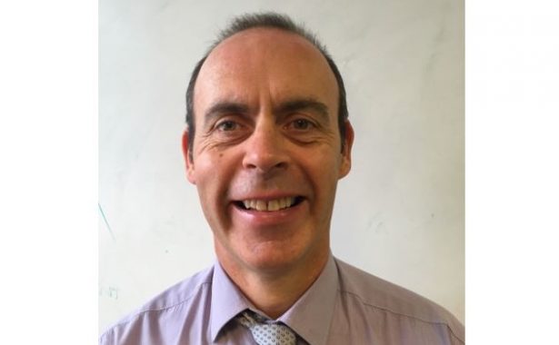 Graham Findlay smiling, wearing shirt and tie.